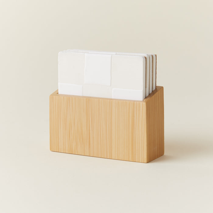 A boxed set of four square stoneware coasters with a neutral hand-painted checkerboard design.