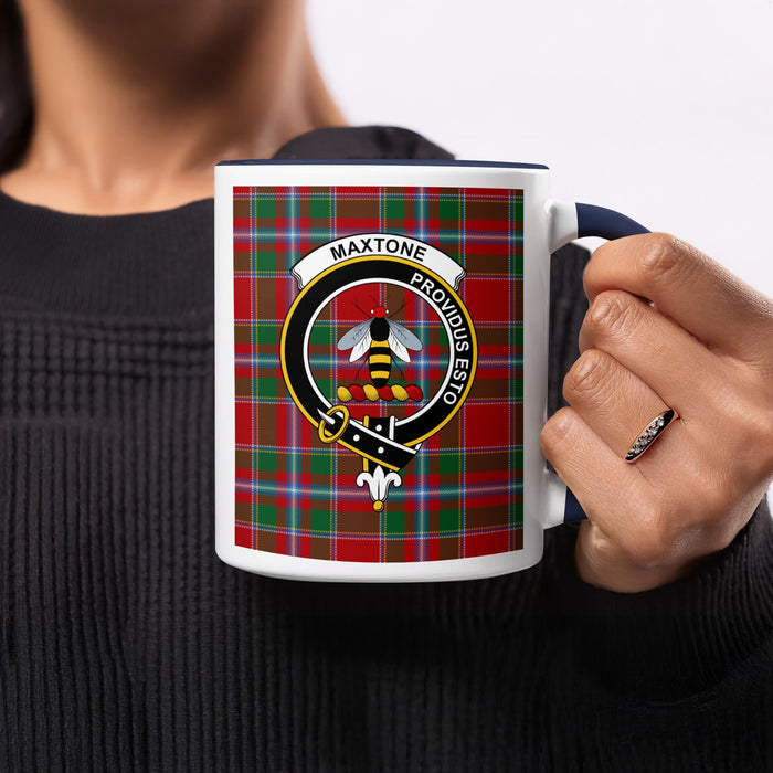 Close-up lifestyle view of Maxtone Scottish family crest artwork on a navy 11 oz accent mug with a tartan background