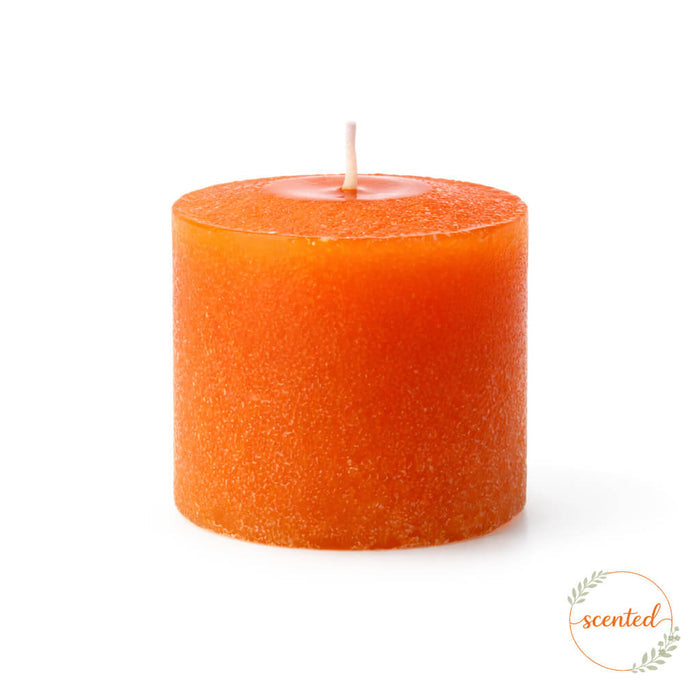 Orange citrus fruit scented votive candle on a white background