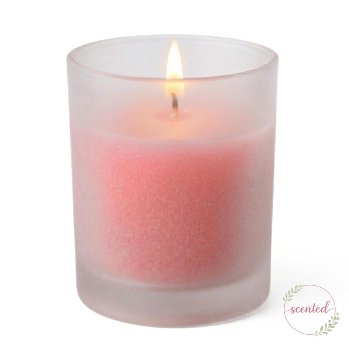 Lit Gardenia scented pink votive candle in a frosted holder