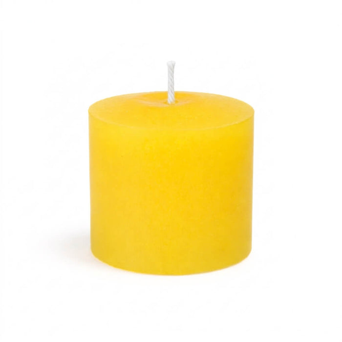 An unlit Yellow unscented votive candle isolated on a solid white background