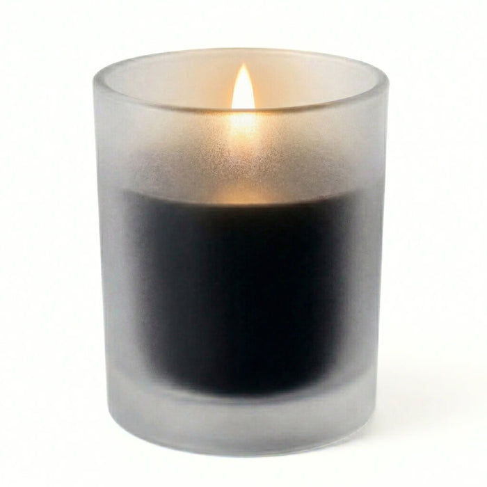 Single unscented black candle burning in a frosted holder