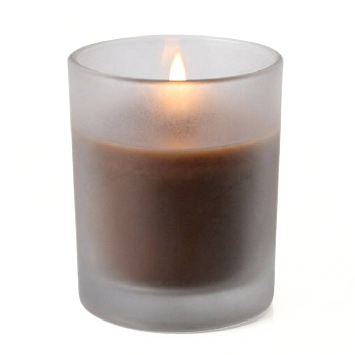 Single unscented brown candle burning in a frosted holder