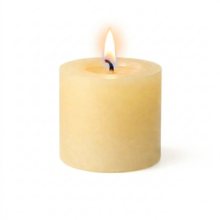 A lit ivory candle glowing with a bright flame on a white background