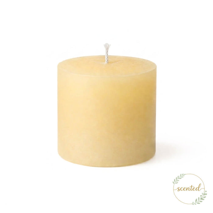 An unlit vanilla scented ivory candle on a white background