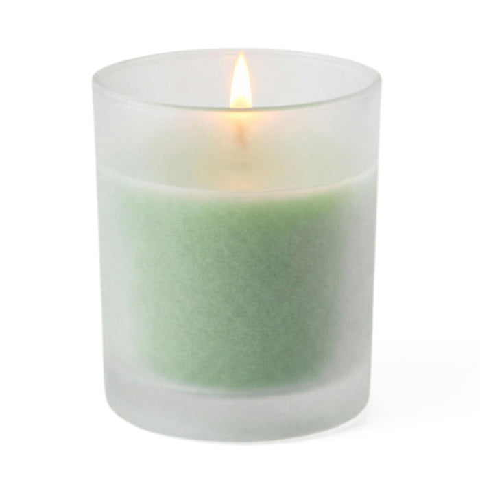 A single lit green candle glowing softly inside Frosted Votive Holders