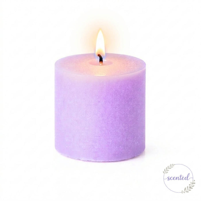 A lit lavender scented candle and a small round logo badge on white
