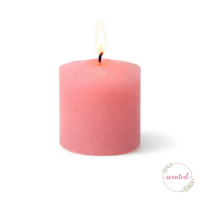 Lit Gardenia scented pink votive candle on a white backdrop