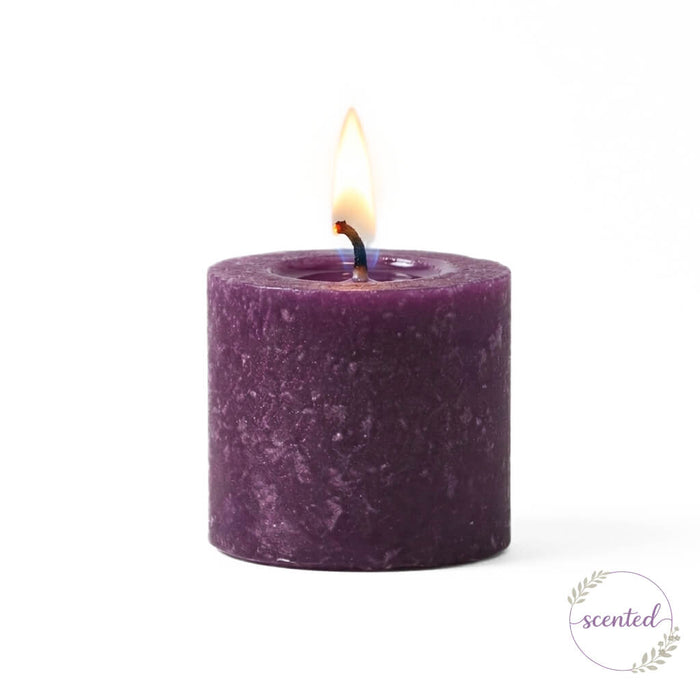 Lit Purple Mulberry scented votive candle isolated on a white background