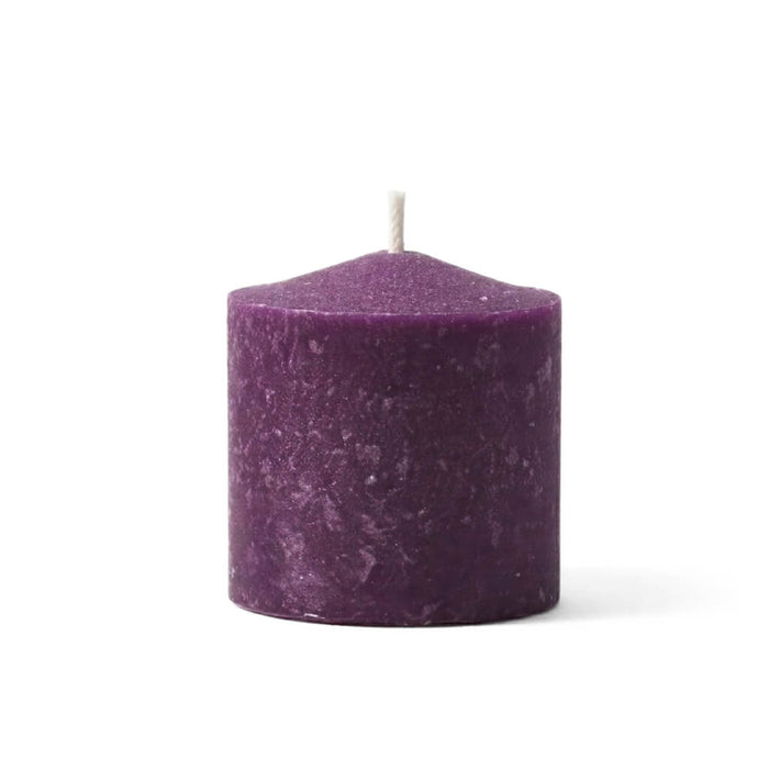 A single purple votive candle