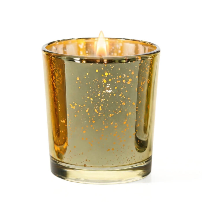 Gold mercury glass votive candle holder with glowing flame on white background