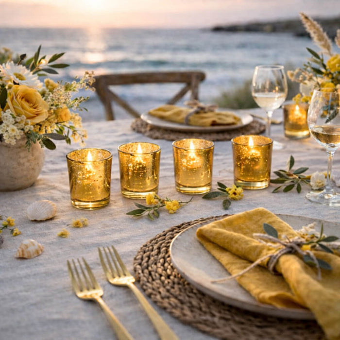 Four Gold Mercury Votive Holders on a linen tablescape at an upscale beachside dinner at sunset