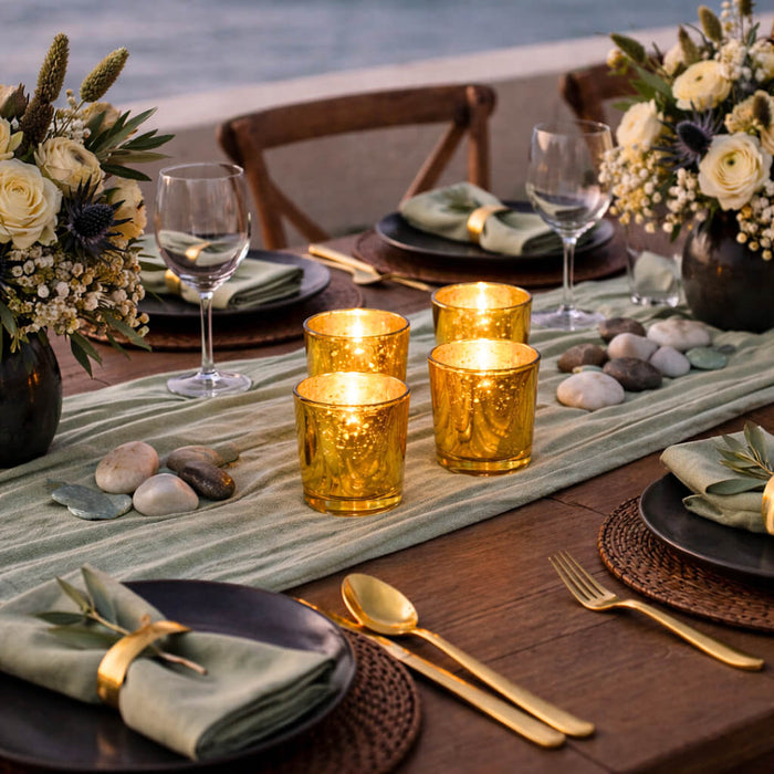 Four Gold Mercury Votive Holders on a coastal table runner with elegant sage green settings